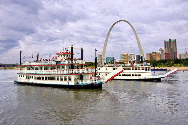 Photo of two riverboats on the river in front of the Gateway Arch