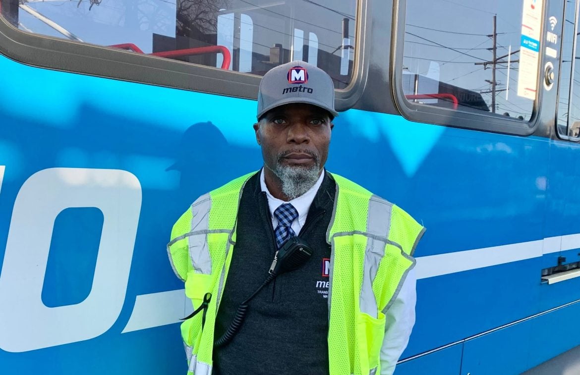 MetroLink Transit Service Manager, Diondre Fulton posing in front of a MetroLink Light Rail Vehicle.