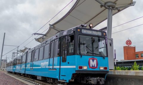 A MetroLink train stops at the Cortex MetroLink station. The platform canopies appear in the background.