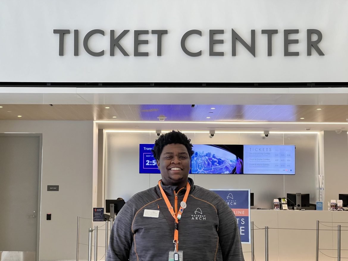 A Gateway Arch Employee smiles near the Ticket Center